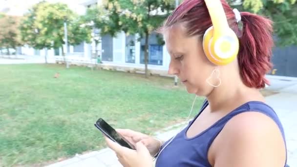 Lachende Vrouw Lopen Luisteren Muziek Met Hoofdtelefoon — Stockvideo
