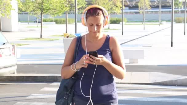 Usmívající Žena Poslouchat Hudbu Při Přes Silnici Přechodu Pro Chodce — Stock video