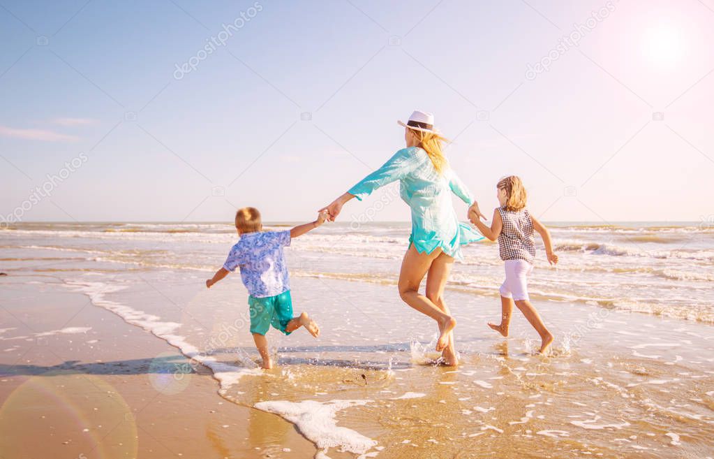happy mom playing whit her children with the sea 