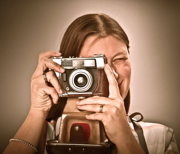 Woman with old camera isolated on grey background