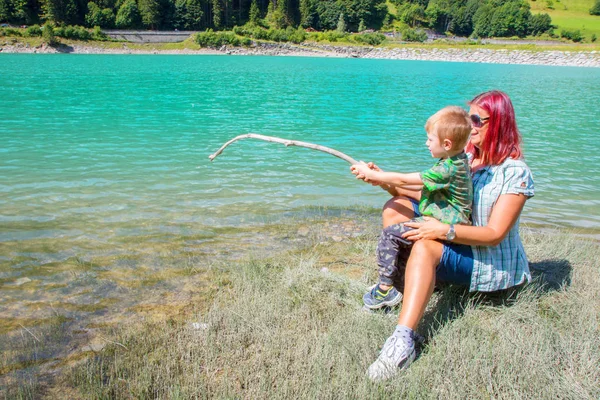 母亲和儿子在湖里钓鱼 — 图库照片