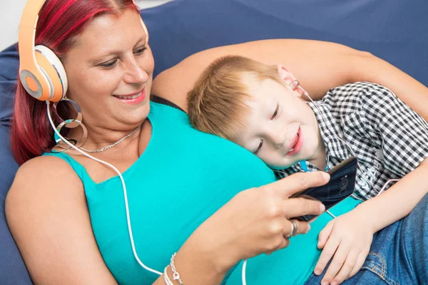 Madre Hijos Con Auriculares Escuchan Música Abrazándose Sofá — Foto de Stock