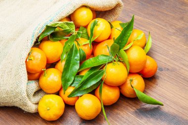 ahşap masa yapraklarda ile taze mandarin portakal meyve