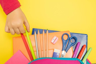 Geri okul kavramı. Okul malzemeleri ile renkli arka plan üzerinde sırt çantası