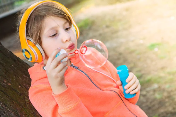 Jeune fille écouter de la musique avec casque souffle bulle de savon — Photo