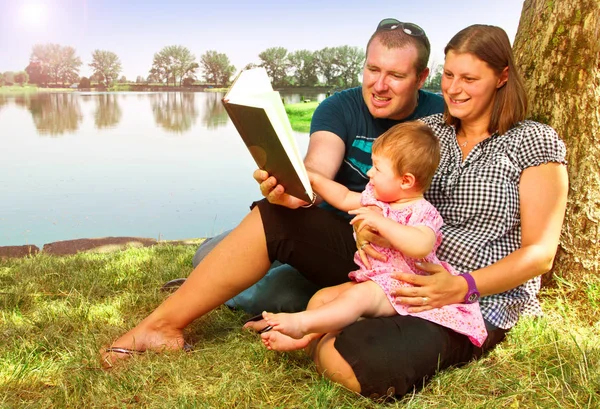 Garçon et fille avec des livres sur la nature près du lac — Photo