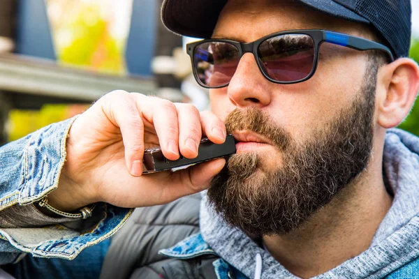 Muž s plnovousem kouří elektronickou cigaretu — Stock fotografie