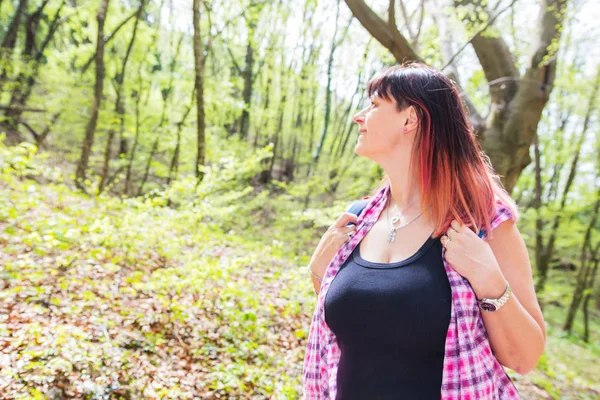 Beautiful woman is looking something while is hiking in the fore — Stock Photo, Image