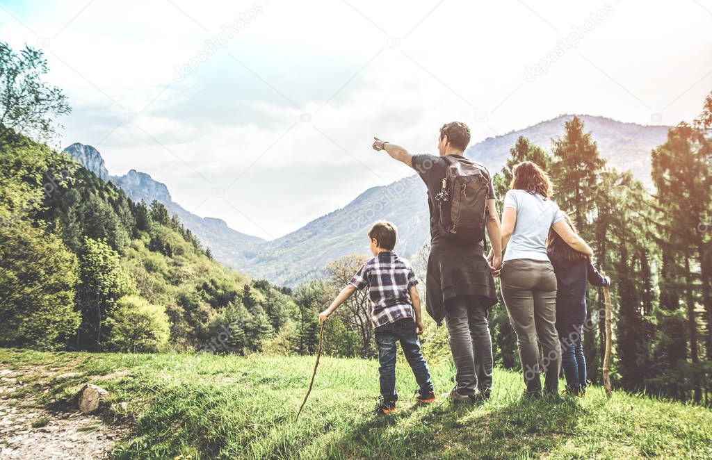 family on a green meadow looking at the mountain panorama