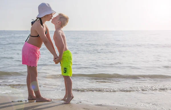 Broer en zus zoenen op een strand op een mooie dag in de zomer — Stockfoto