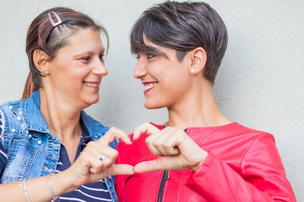 Casal lésbico formando forma de coração com as mãos — Fotografia de Stock