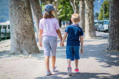 erkek ve kız kardeş el sıkışarak birlikte yürümek