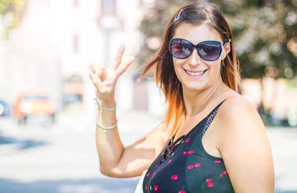通りを歩くサングラスをかけた笑顔の夏の女性 — ストック写真
