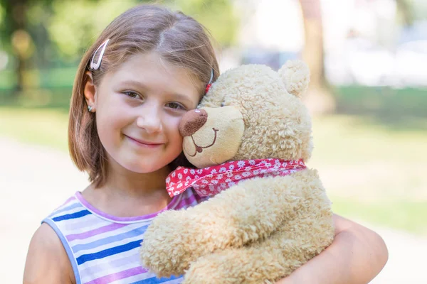 Μικρό κορίτσι κρατώντας μεγάλο αρκουδάκι έξω — Φωτογραφία Αρχείου