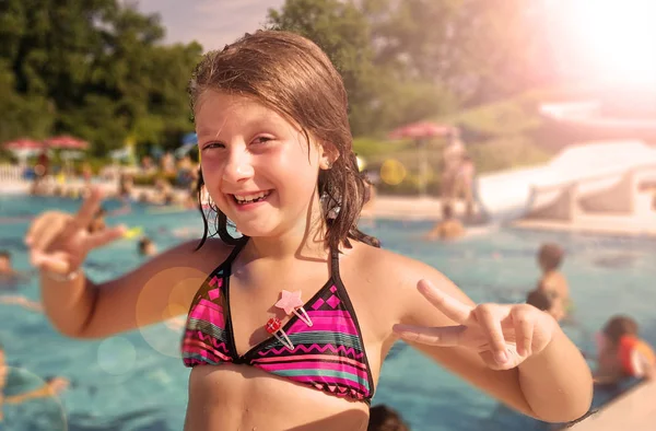 Menina sorrindo está desfrutando na piscina em um dia de verão — Fotografia de Stock