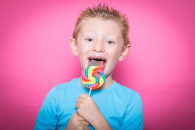 Tatlı lolipop üzerinde renkli eğleniyor ile mutlu gülümseyen çocuk