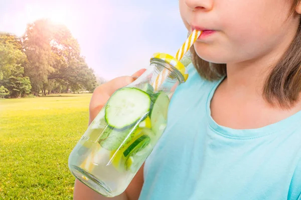 Barn dricker färskvatten frukt med halm — Stockfoto