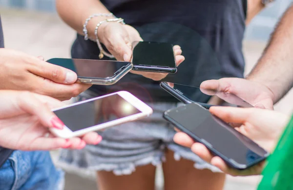 Liten grupp människor använda mobiltelefoner tillsammans — Stockfoto