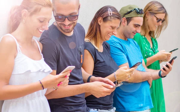 Grupp vänner tittar på smarta mobiltelefoner-Millennials gen — Stockfoto
