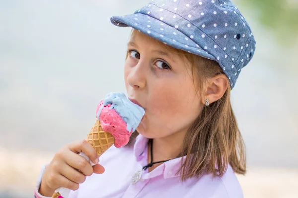 Feliz chica joven está comiendo un helado — Foto de Stock