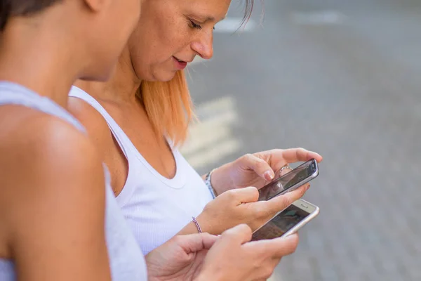 Freundeskreis schaut gemeinsam aufs Smartphone — Stockfoto