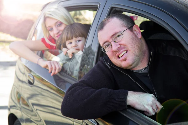 Happy family look out from car windows — Stock Photo, Image