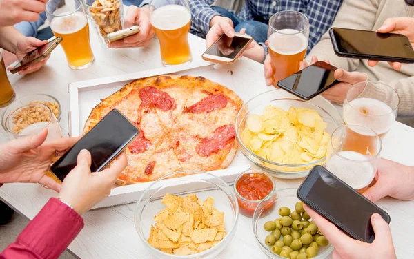 친구들끼리 스마트폰으로 피자를 맥주를 마시는 — 스톡 사진