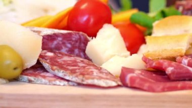 Salam, jambon, beyaz üzüm ve karışık peynirli ahşap kesim tahtası.