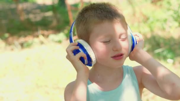 公园里拿着耳机跳舞听音乐的孩子 — 图库视频影像