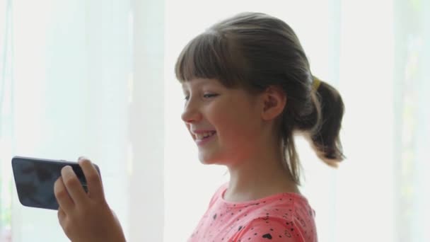 年轻微笑的女孩与人交谈 微笑着打一个视频电话 — 图库视频影像