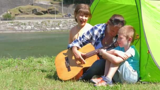 Uma Família Feliz Acampando Rio Tocando Guitarra Cantando Uma Música — Vídeo de Stock