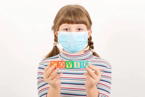 Covid 19病毒的流行 用Covid 19写的带有木制立方体的信的年轻女孩 — 图库照片