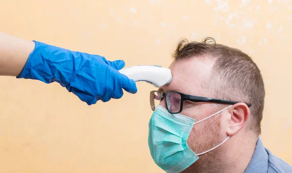 Coronavirus Sjuksköterska Bär Handskar Och Håller Medicinsk Infraröd Panna Termometer — Stockfoto