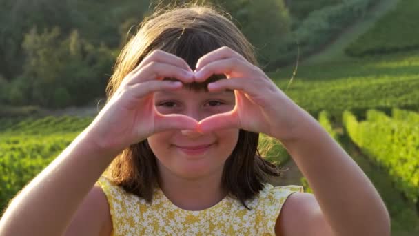 Młoda Uśmiechnięta Dziewczyna Sprawia Znak Serca Dłońmi — Wideo stockowe