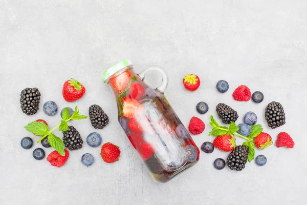 Health care, fitness, healthy nutrition diet concept. Fresh cool berry and mint infused water,  detox drink, in a glass jar.