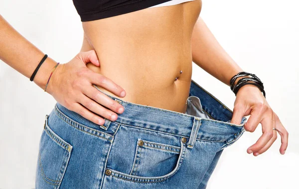 ダイエット概念 大きなジーンズで食事をした後の若い女性 — ストック写真