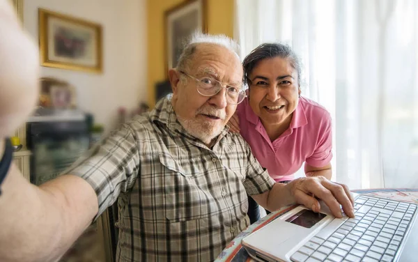 Hombre Mayor Con Cuidador Tomando Una Foto Selfie Casa —  Fotos de Stock