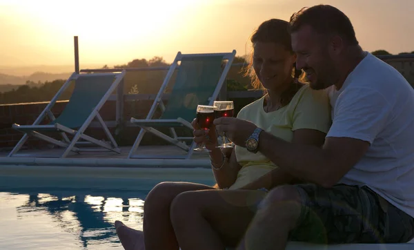 若いカップルは日没時に赤ワインを飲む食前酒を飲んで抱っこを交換する — ストック写真
