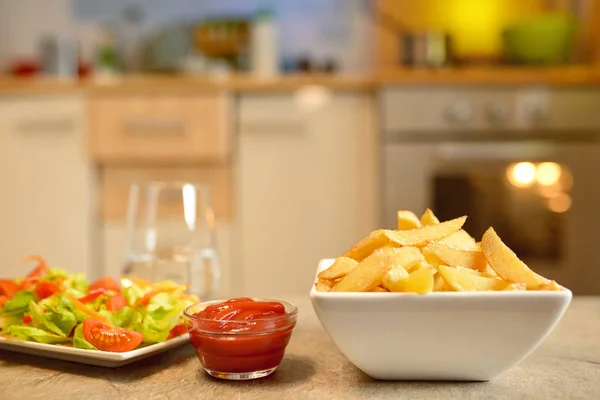 Batatas fritas e salada na mesa — Fotografia de Stock