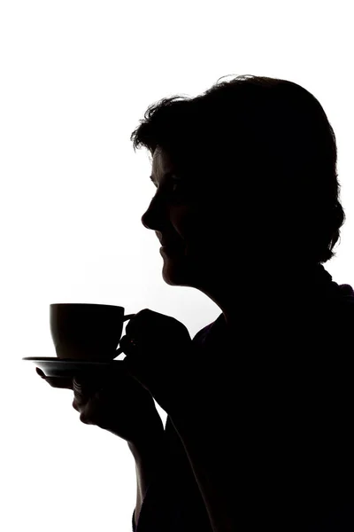 Силуэты женщины, пьющей кофе — стоковое фото