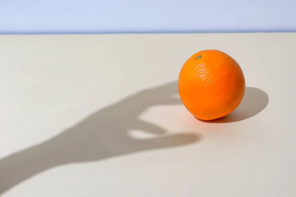 Mão masculina pega uma laranja — Fotografia de Stock