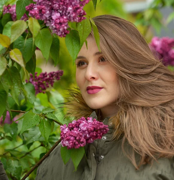 Chica joven posando cerca de arbustos lila —  Fotos de Stock