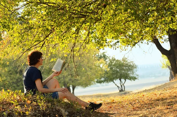 Žena četla v podzimním lese — Stock fotografie