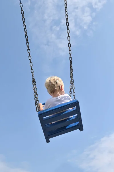 Boy Cochlear Implants Riding Swing Summer Park — Stock fotografie