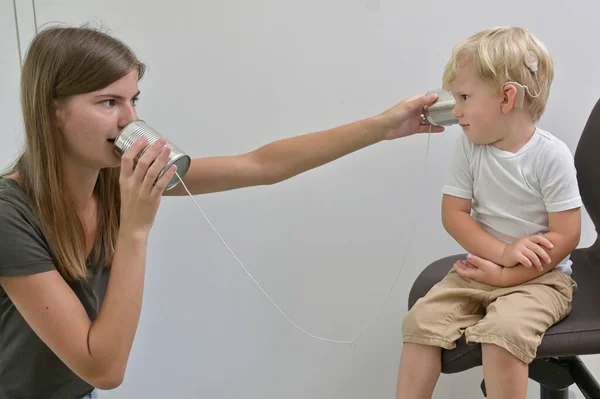 一个有人工耳蜗植入的男孩会玩铁皮手机 — 图库照片