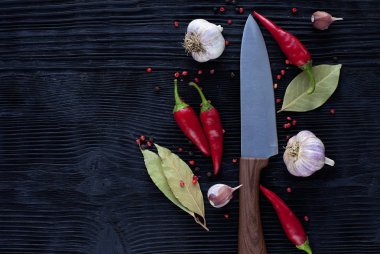 ahşap koyu arka plan üzerinde şef bıçak sarımsak biber