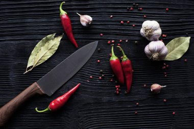 siyah ahşap arka plan üzerinde şef bıçak sarımsak biber