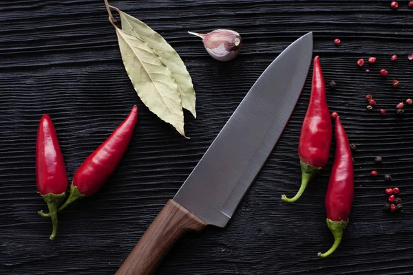 Chef  knife garlic red chili on black wooden background — Stock Photo, Image