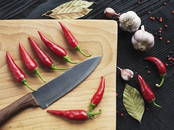 Coltello chef peperoncino rosso e spezie su sfondo di legno — Foto Stock