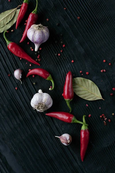 Czosnek czerwona papryka chili na czarnym drewnianym ciemnym tle — Zdjęcie stockowe